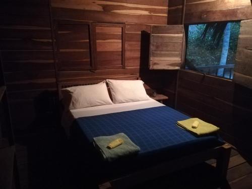 a small bedroom with a bed and a window at Cabanas Las Estrellas in Palomino