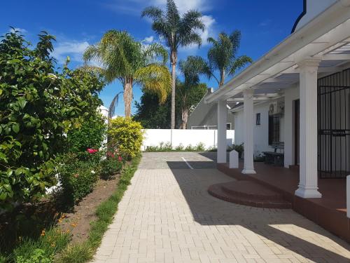 a porch of a house with palm trees at Outeniqua en Route in George