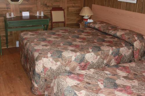 a hotel room with two beds and a desk at Motel Boisé in Blainville