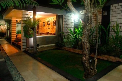 a house with a tree in the middle of a yard at Villa Rumah Putih Abu Abu in Senggigi 