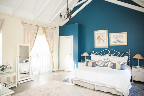 a bedroom with blue walls and a bed and a window at The Plantation in Port Elizabeth