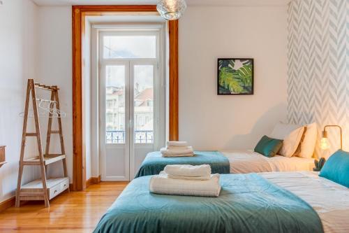 リスボンにあるBaixa most beautiful and luminous 3 BDR flatのベッド2台、はしご、窓が備わる客室です。