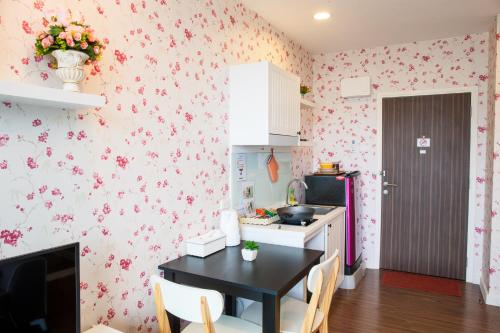 a kitchen with pink flowers on the wall at Courtyard Khaoyai by Paka in Mu Si