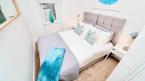 una camera da letto con un letto bianco e una finestra di Snug - Tùr Sealladh Apartment a Helensburgh
