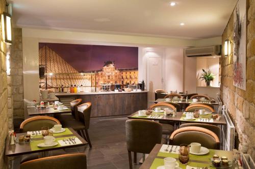 a restaurant with tables and chairs and a bar at Hotel Elysa-Luxembourg in Paris