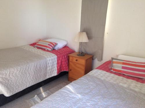 a small bedroom with two beds and a lamp at Bahía Pelícanos in Ventanas