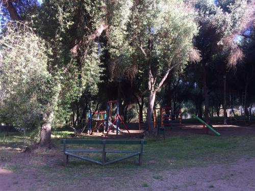 a park with a playground with trees and a bench at Bahía Pelícanos in Ventanas