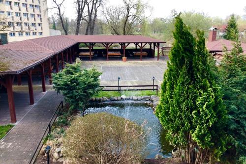 een park met een tuinhuisje en een vijver bij Hotel Piastowska in Chojna