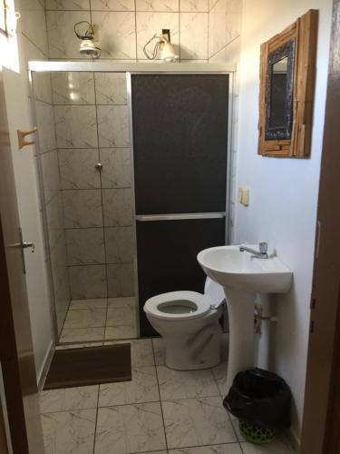 a bathroom with a shower and a toilet and a sink at Hotel Patropi in Assis