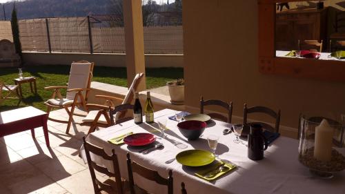 - une table avec un chiffon de table blanc et des bouteilles de vin dans l'établissement Les Trois Oliviers, à Forcalquier