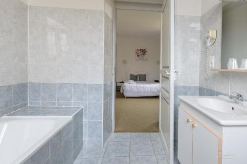 uma casa de banho com uma banheira e um lavatório em Hôtel Pedussaut em Saint-Gaudens