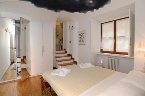- une chambre blanche avec un lit et un escalier dans l'établissement Palazzo Graneri, à Turin