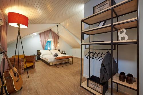 a bedroom with a bed and a room with a guitar at Bubalus Boutique Rooms in Trogir