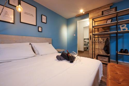a bedroom with a white bed and blue walls at Bubalus Boutique Rooms in Trogir