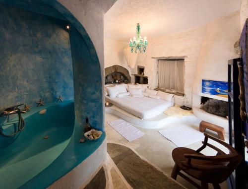 a bedroom with a bed and a tub in a room at Amelia Beachfront Villa in Korissia