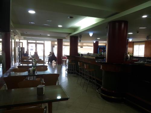 a restaurant with tables and chairs and a bar at Hostal Mediterraneo in El Ejido