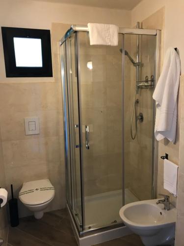 a bathroom with a shower and a toilet and a sink at Casale Degli Angeli in Vieste