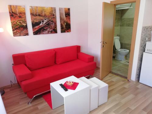 a living room with a red couch and a table at Plitvice Mountain Spring in Korenica