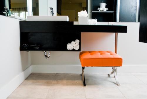 an orange chair sitting under a black desk at Hotel Current in Long Beach