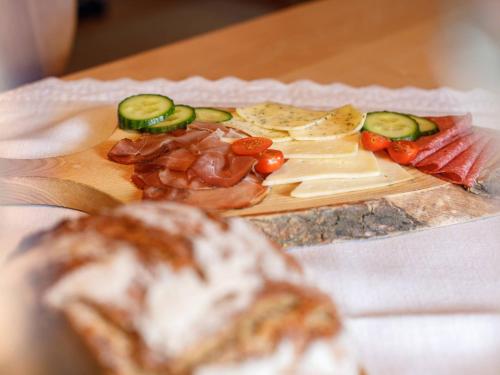 een bord met eten met vlees en kaas op een tafel bij Steinberger Hof Alm inkl. Chiemgau Karte in Ruhpolding
