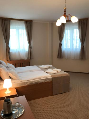 a bedroom with a large bed and two windows at Bucharest Downtown Inn in Bucharest