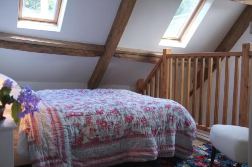 ein Schlafzimmer mit einem Bett und zwei Fenstern in der Unterkunft Bake House Cottage in Shepton Mallet