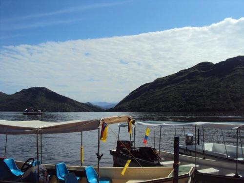 a boat on the water with mountains in the background at Hotel Bellavista Isla del Sol in Prado