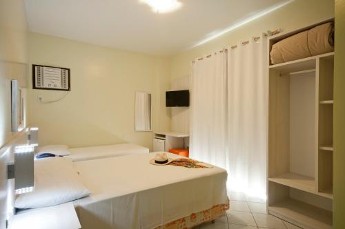a small room with two beds and a tv at Pousada Villa Atlântica in Balneário Camboriú
