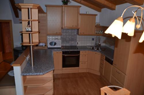 a kitchen with wooden cabinets and a stove top oven at Appartement Leirer in Alpbach