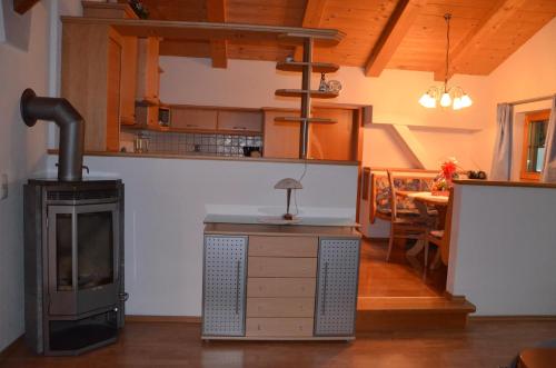 a living room with a wood stove and a kitchen at Appartement Leirer in Alpbach