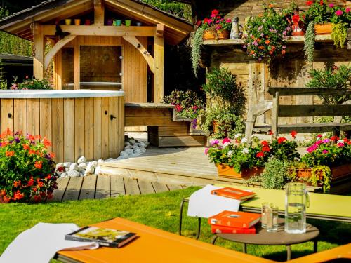 um jardim com um deque de madeira e uma banheira de hidromassagem em Auberge du Manoir em Chamonix-Mont-Blanc