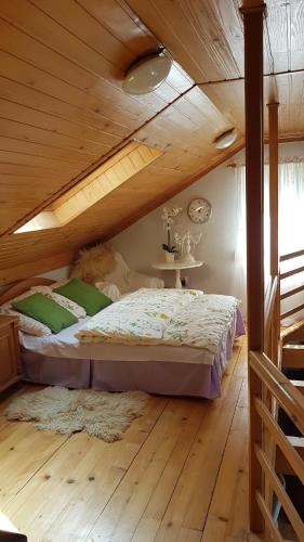 a bed in a room with a wooden ceiling at Fort Janowek in Janówek