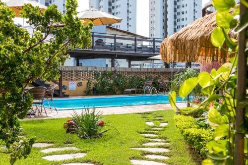 a backyard with a swimming pool and a resort at Pousada da Terra in Natal