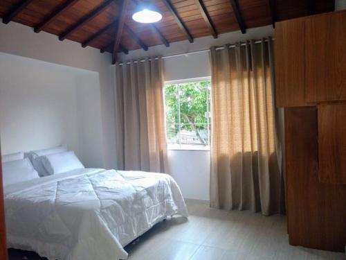 1 dormitorio con cama y ventana en Apartamento no Centro Búzios, en Búzios