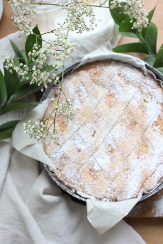 a cake sitting on top of a table with flowers at Ca'Vermiglia B&B in Bologna