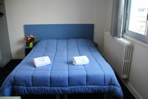 a blue bed with two white pillows on it at Le Petit Majestic in Lourdes