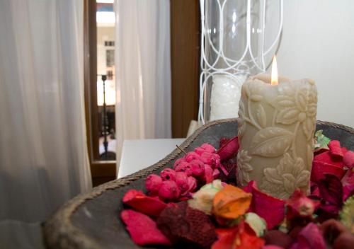 a candle sitting on a table with pink flowers at Residencial Terra de Mar Calpe, Grupo Terra de Mar, alojamientos con encanto in Calpe