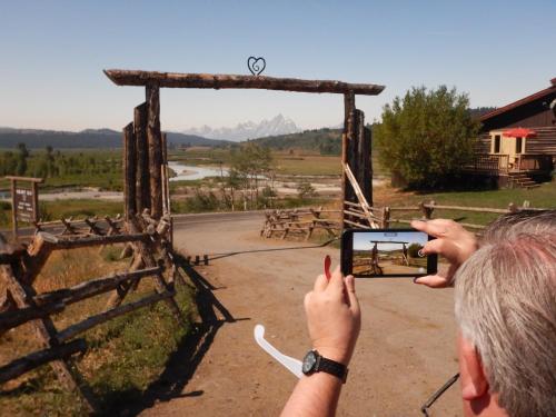 a man taking a picture of a gate with his cell phone at Buffalo Valley Ranch in Moran
