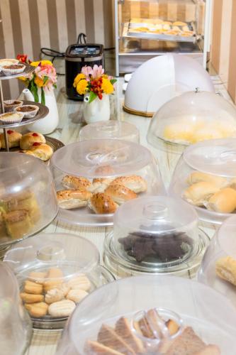 a table topped with clear containers filled with food at Pousada da Terra in Natal