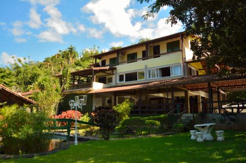 una casa con un jardín delante de ella en Pousada Agua Cristalina, en Cachoeiras de Macacu