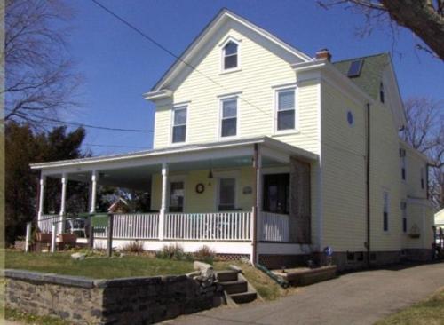 a large white house with a porch at The Stirling House Waterfront Inn Greenport in Greenport