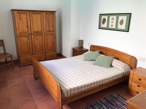sypialnia z drewnianym łóżkiem z 2 poduszkami w obiekcie Casa Beatriz w mieście Famara