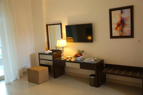 a living room with a desk and a television on the wall at Gewan Hotel Cairo in Cairo