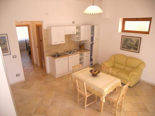 a kitchen and living room with a table and a couch at Villa Alessia in Paestum