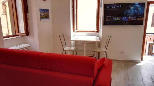 a living room with a red couch and a table at Appartamento Madda in La Maddalena