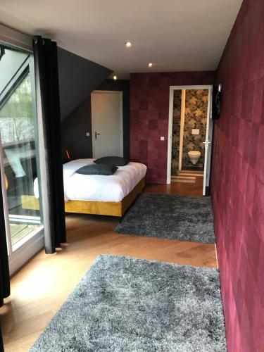 a bedroom with a bed and a red wall at Hotel Buenos in Geldrop