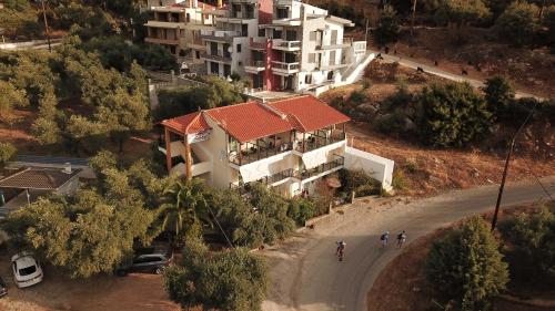 dos personas caminando por un camino delante de una casa en Studios Apollon, en Chrysi Ammoudia