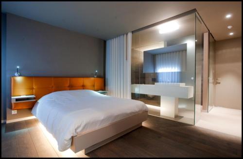 ein Schlafzimmer mit einem großen weißen Bett und einem Waschbecken in der Unterkunft Hotel Shamrock in Tielt