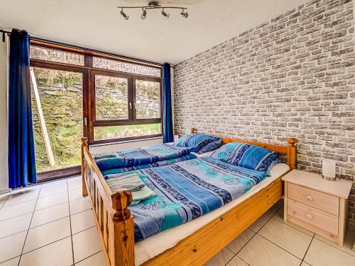 ein Schlafzimmer mit einem Bett und einer Ziegelwand in der Unterkunft Gästehaus Eschbach in Monschau