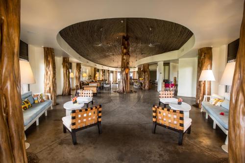 a lobby with tables and chairs and a large ceiling at Nayara Hangaroa in Hanga Roa